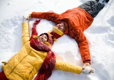 zwei Leute liegen im Schnee